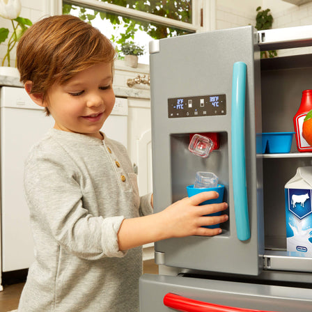 First Fridge - 
Built-in ice dispenser releases plastic ice cubes with the push of a button and makes crushed ice and water dispensing sounds.